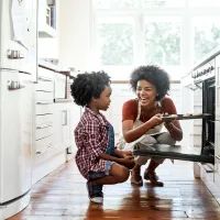 mom and son in kitchen taking something out of the oven